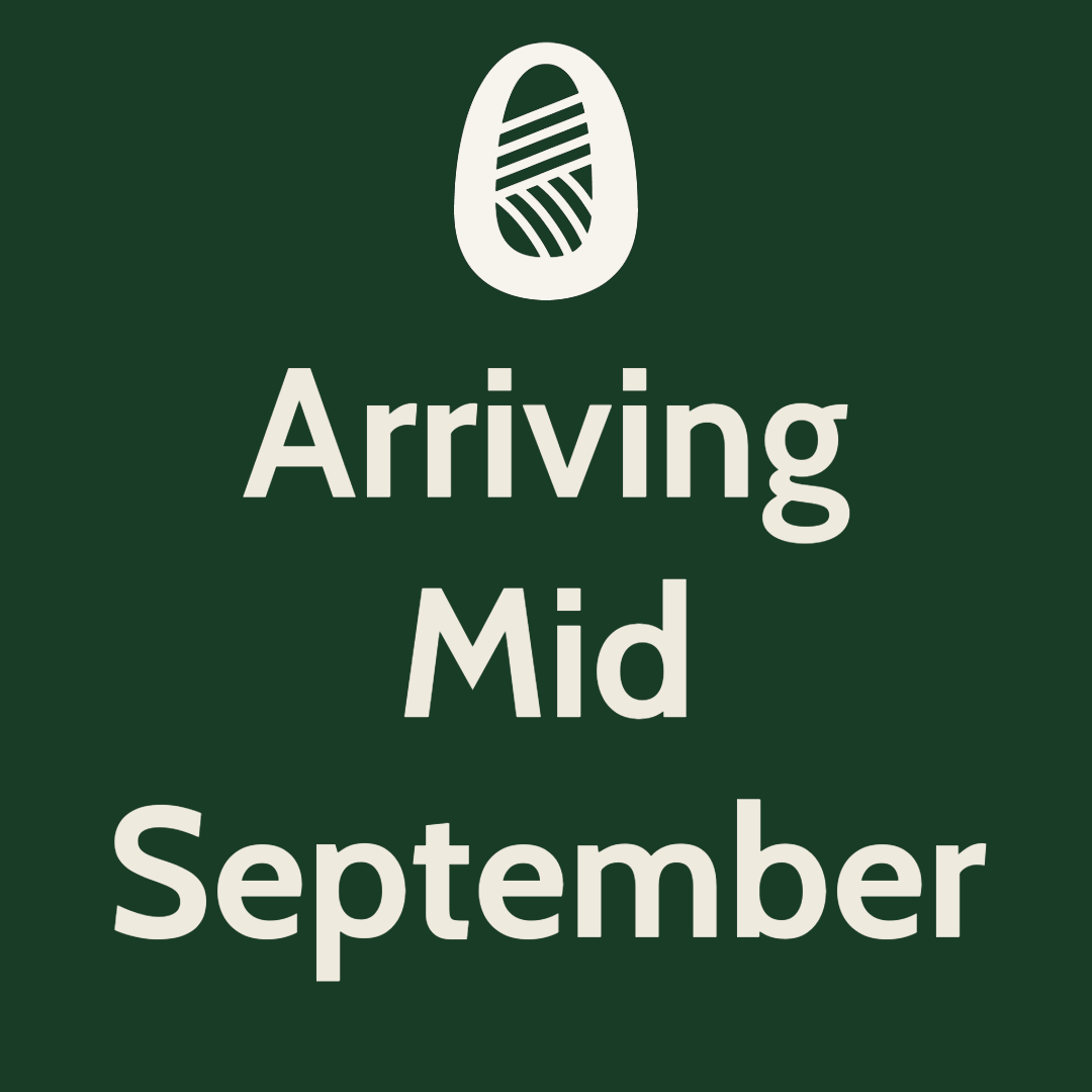 A dark green square sign with a white stylized logo at the top and large white text reading 'Arriving Mid September'.