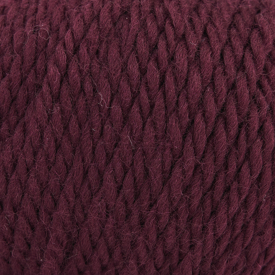 Close-up of a ball of burgundy Mode at Rowan Chunky Wool yarn with a textured surface.