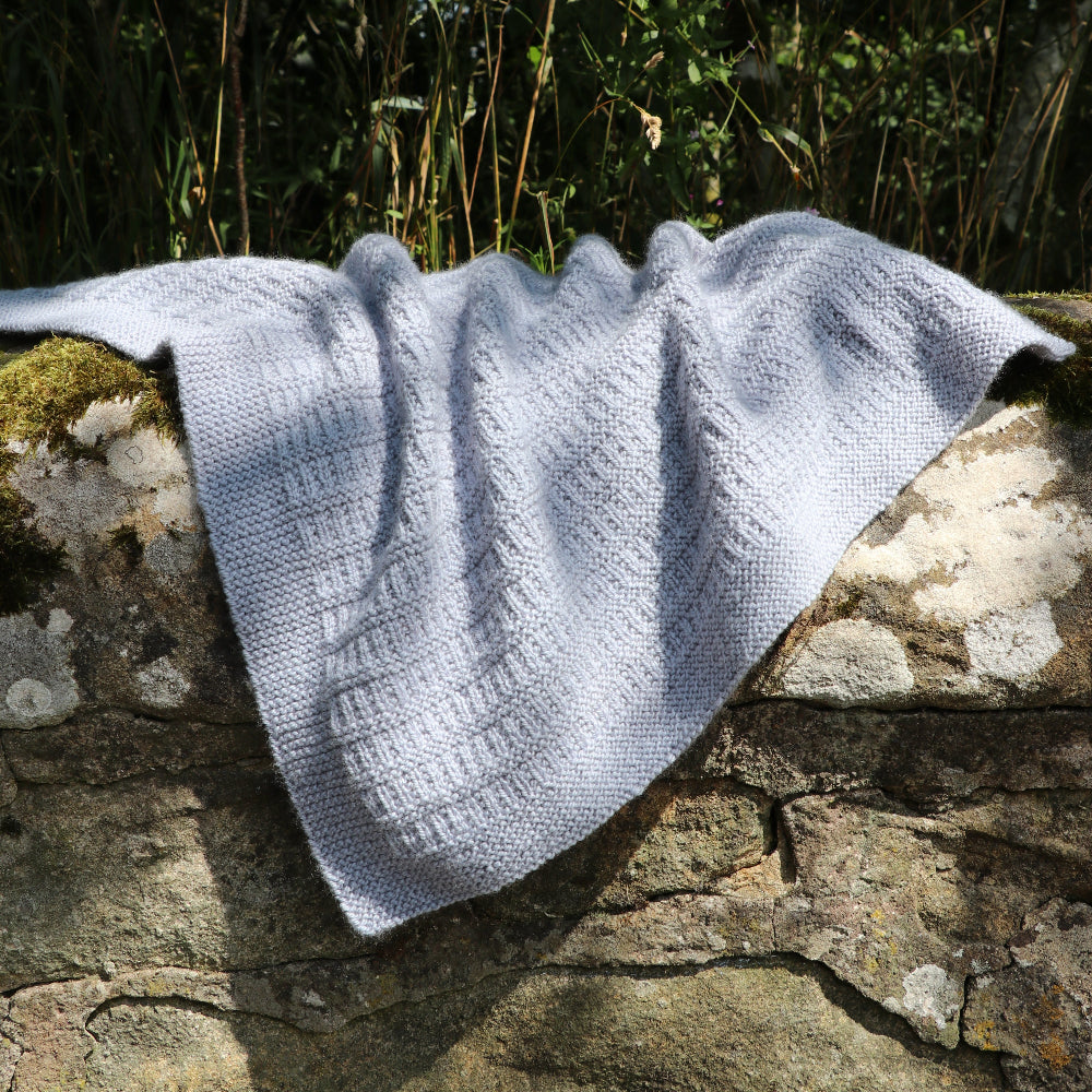 The Cassilis Baby Blanket knitted in Orry Yarn Merino DK, showing the textured stitch pattern and garter edge