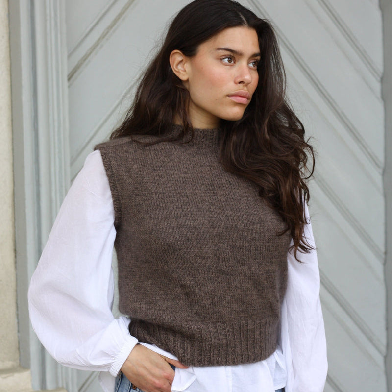 The Knitting for Olive Olive's Vest slipover worn over a white shirt with jeans