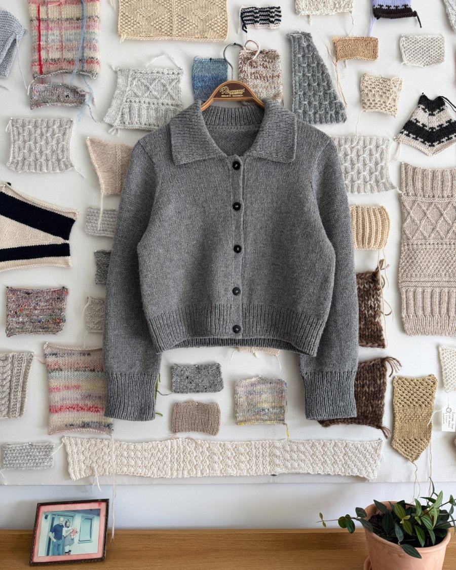 Light grey PetiteKnit Petra Jacket hanging on a board